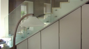 Лестница с мраморными ступенями и ограждением из стекла в квартире