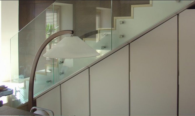Лестница с мраморными ступенями и ограждением из стекла в квартире